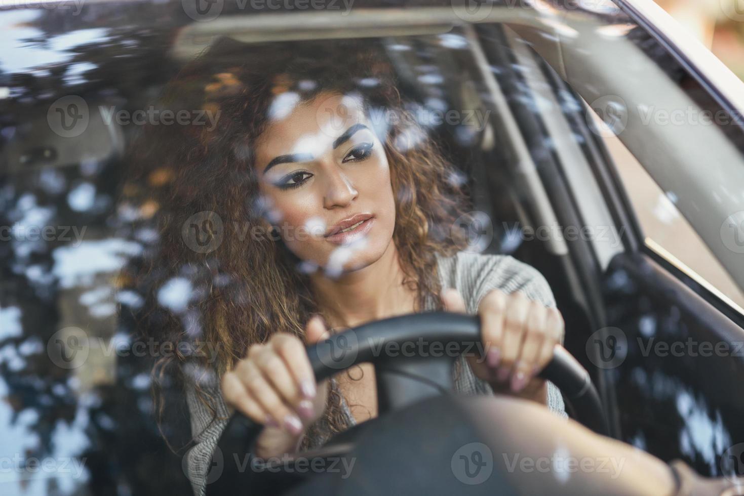 junge arabische frau in einem weißen auto, das durch das fenster schaut foto