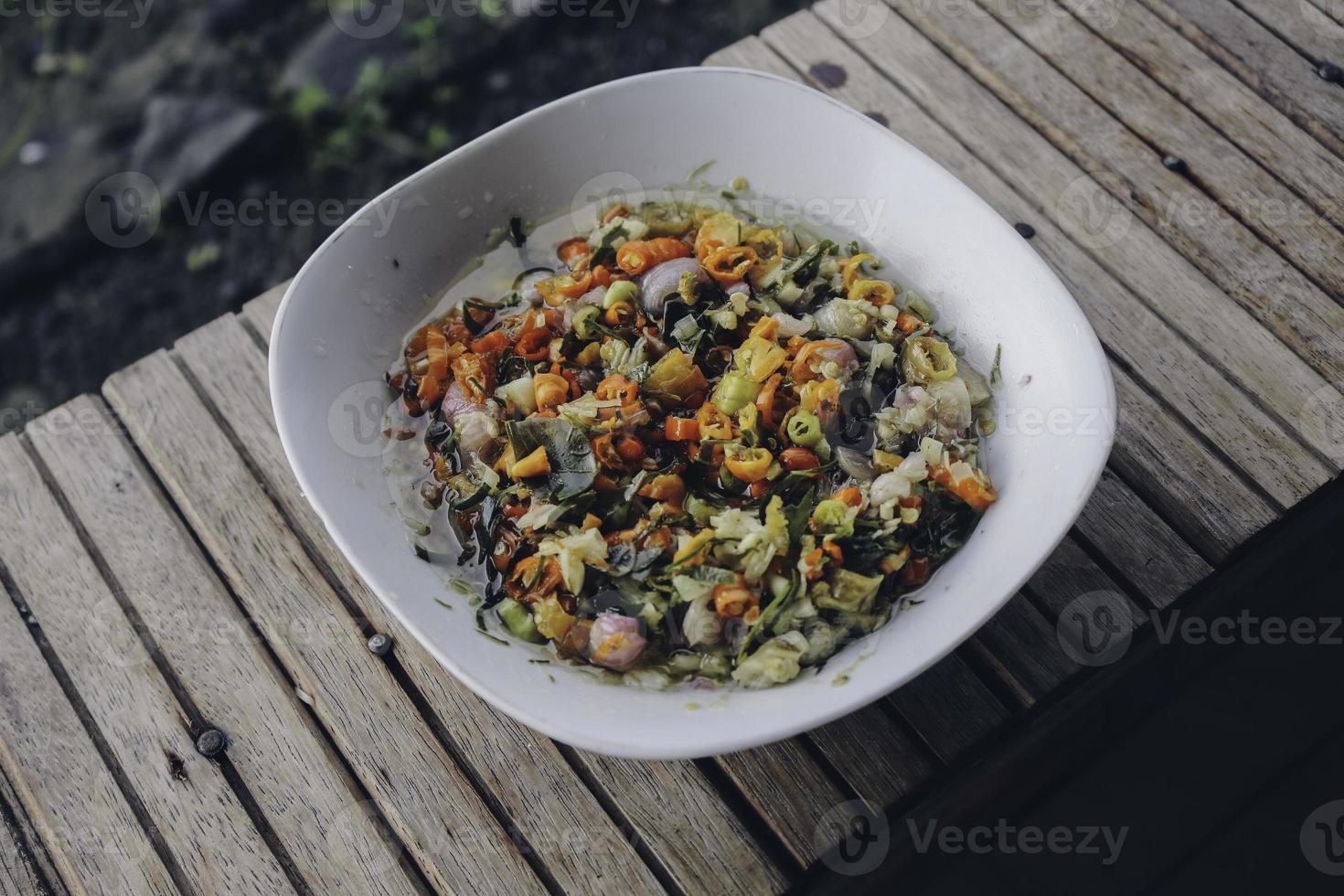 sambal matah. traditionelles rohes chili- und zitronengras-relish aus bali. auf einer weißen Schale plattiert. foto