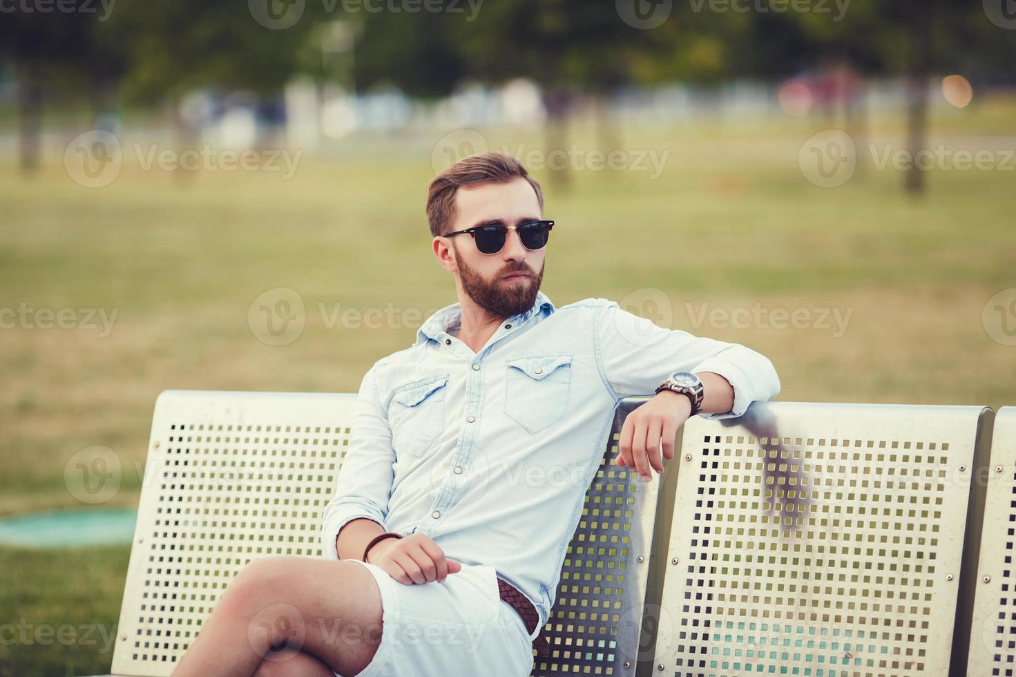 schöner Mann auf der Bank foto