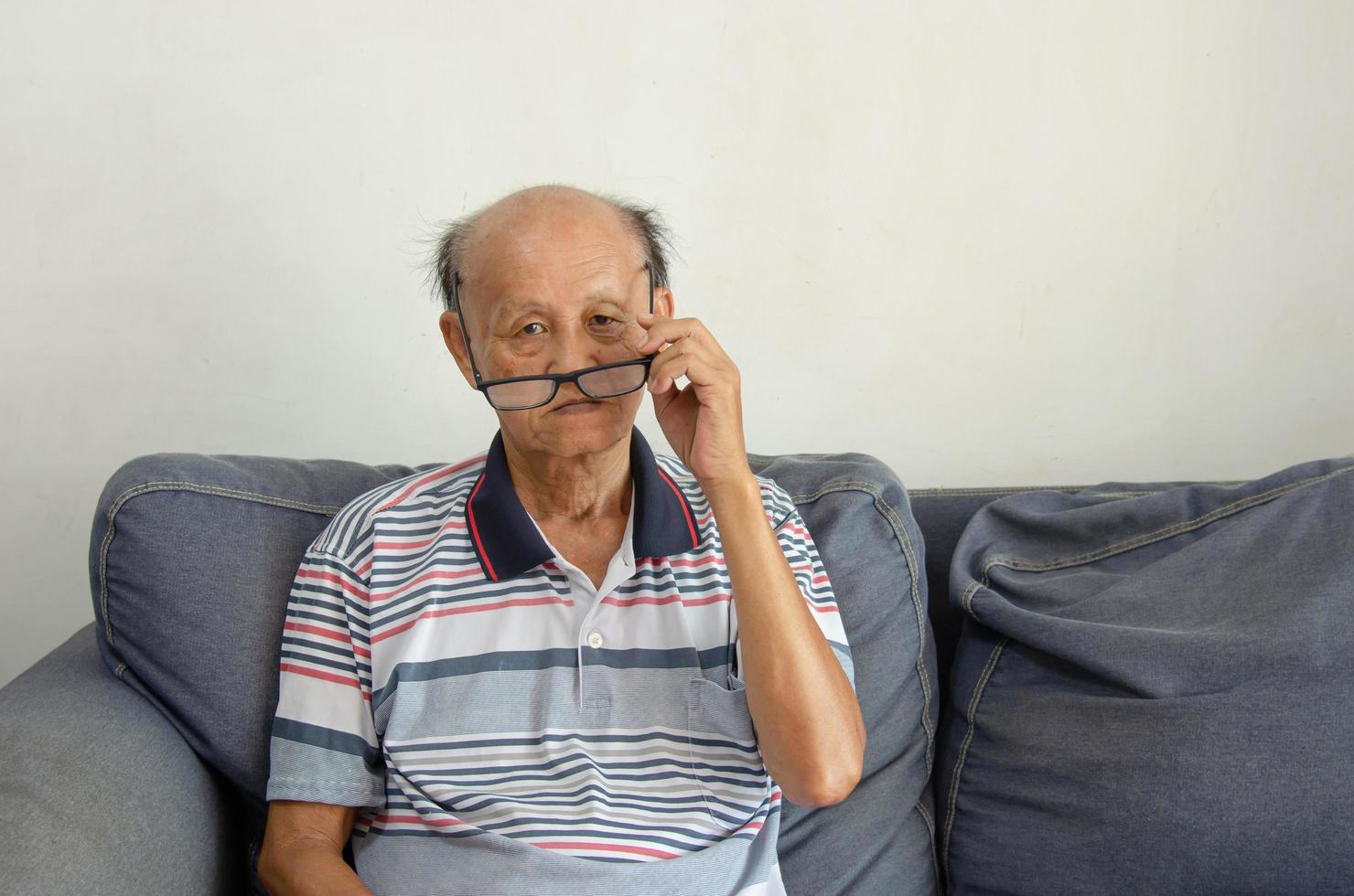 Glatzköpfiger asiatischer älterer Mann mit schwarzer Brille foto