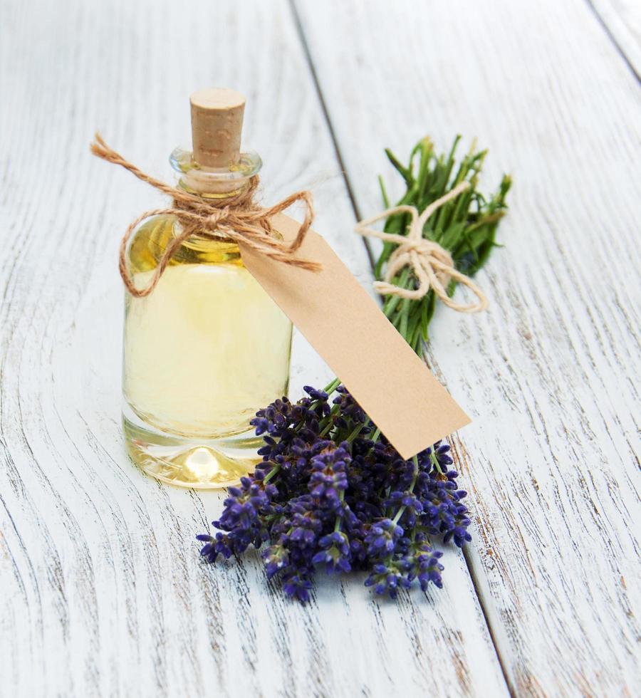 Flasche mit Öl, leerem Etikett und Lavendelblüten foto