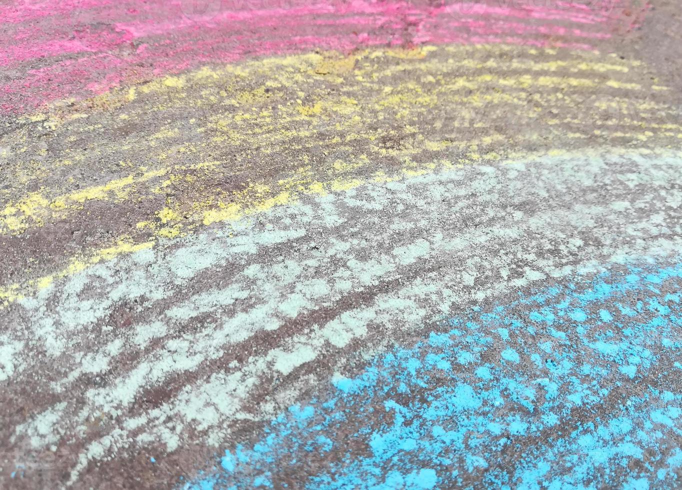 Regenbogen wird mit Kreide auf den Asphalt gezeichnet. farbiger Sommerhintergrund. kinder zeichnen, lgbt-symbol foto