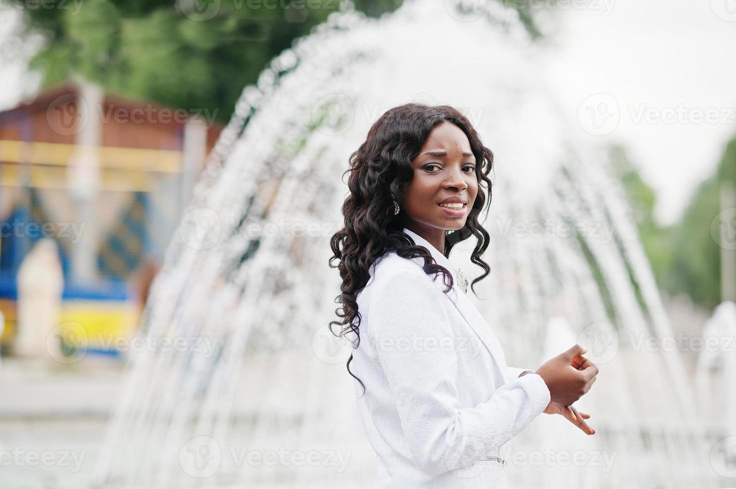 stilvoller und schöner schwarzer afroamerikanermädchenhintergrundbrunnen in der stadt foto