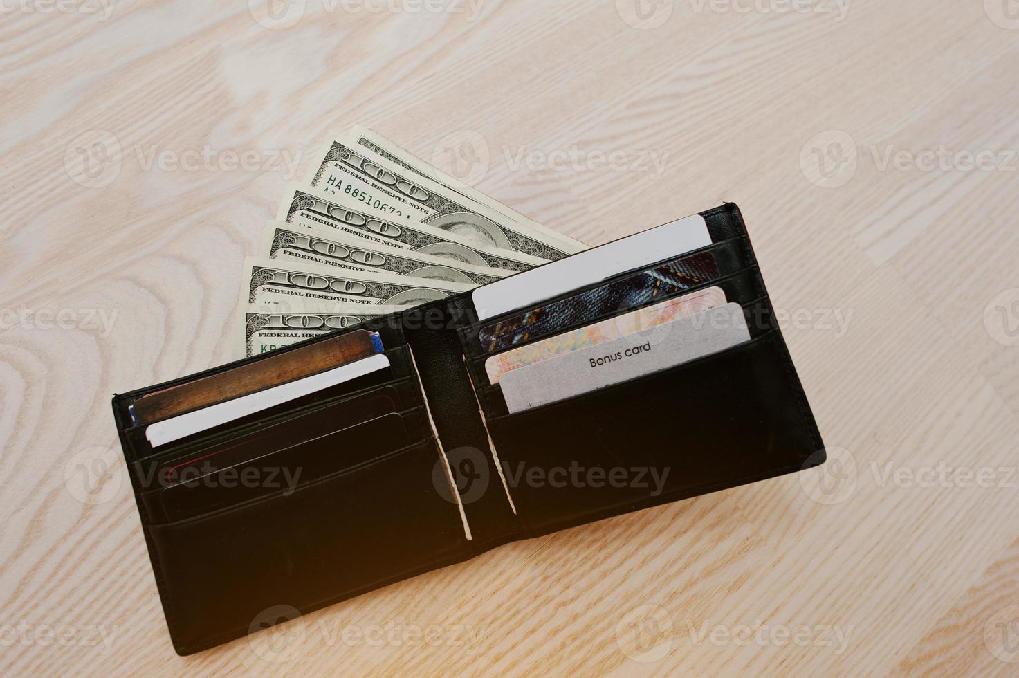 Dollar mit Kreditkarten in der schwarzen Ledergeldbörse foto