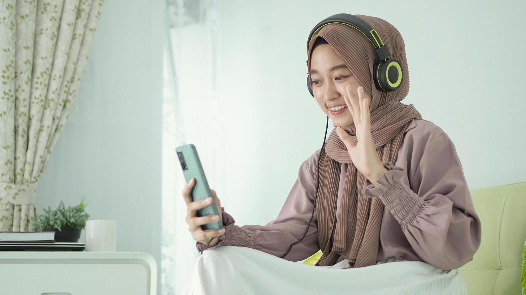 schöne frau im hijab grüßt per videoanruf glücklich zu hause foto