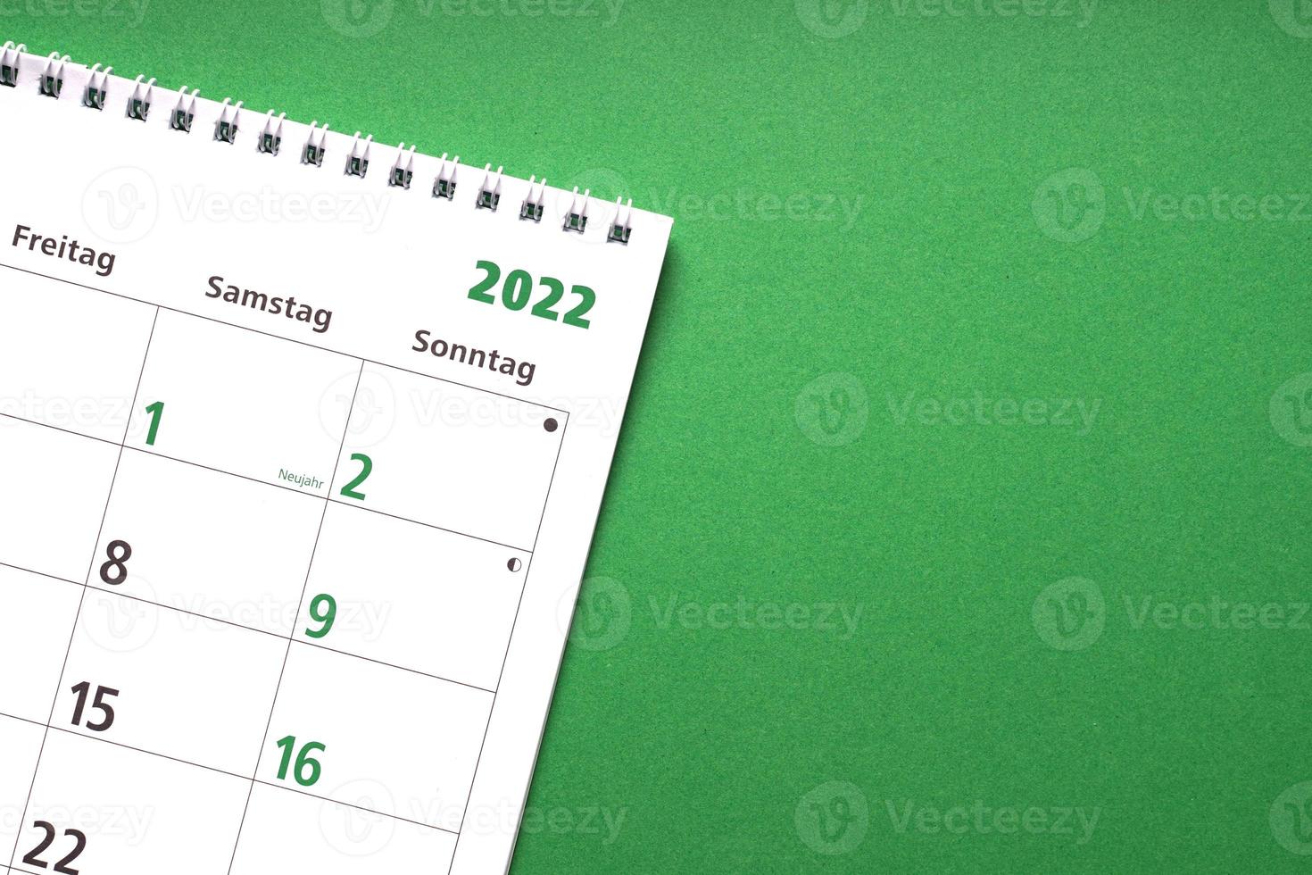 Deutscher Kalender für das neue Jahr 2022 auf grünem Papierhintergrund foto