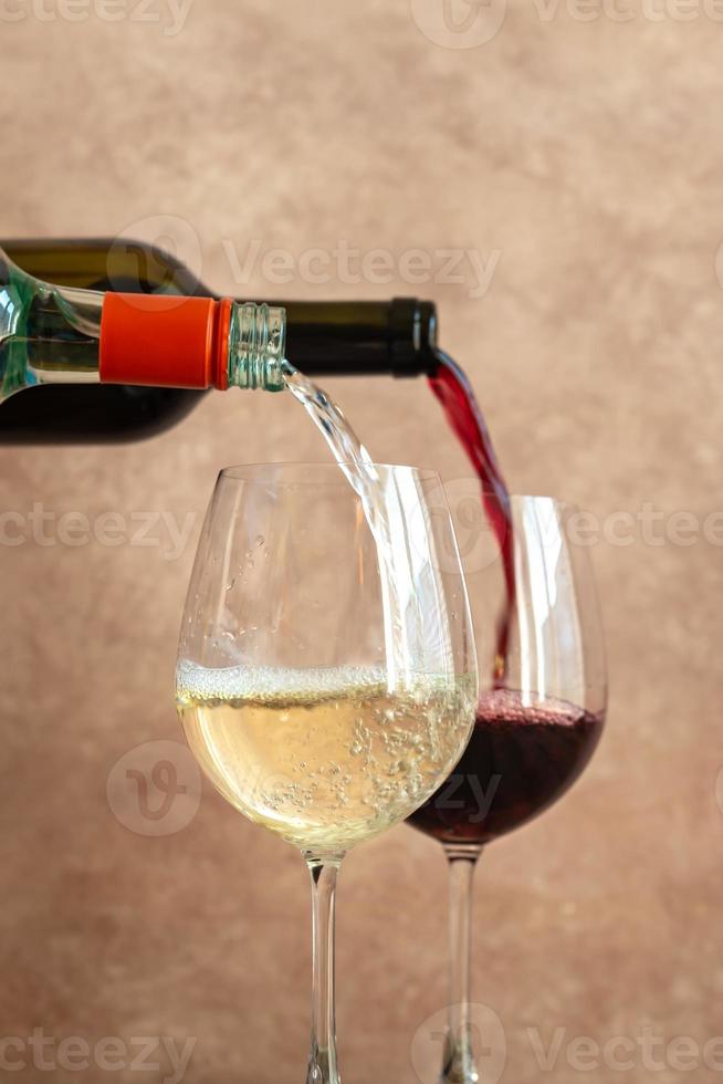 Weiß- und Rotwein in Gläser gießen foto