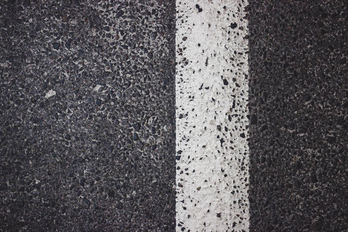 Asphaltstraße mit weißer Streifenstruktur foto