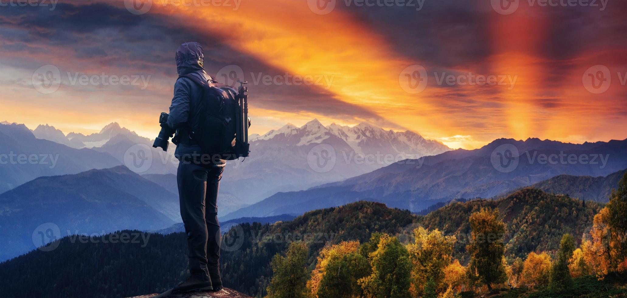 professioneller fotograf macht fotos mit großer kamera auf felsgipfel