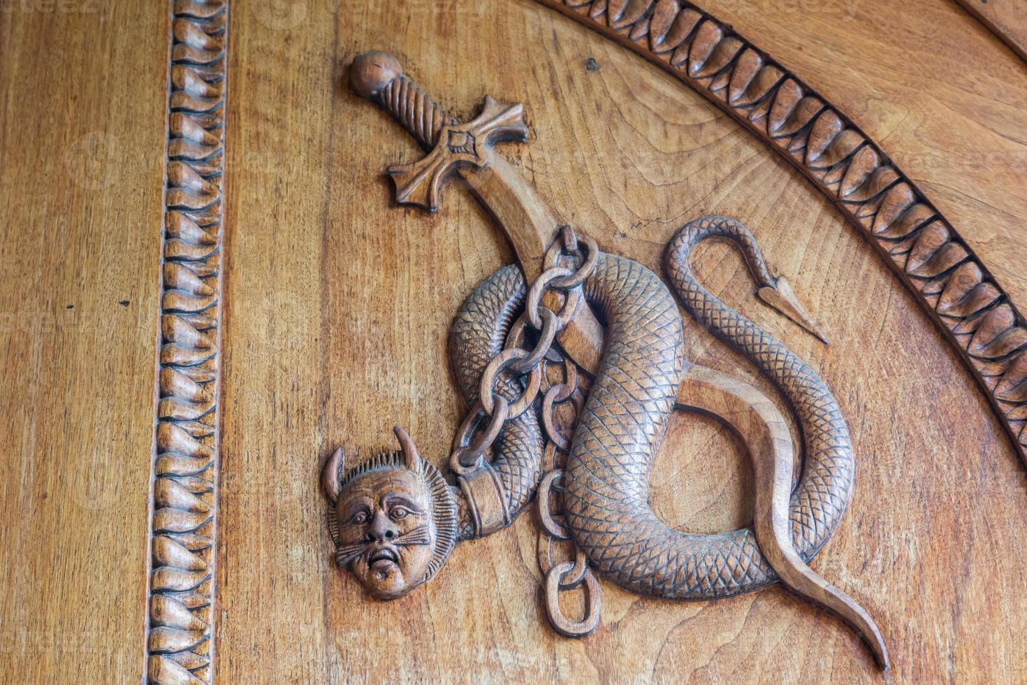 Symbol der Teufelsschlange. Fantasy-Zauberwesen an einer alten Tür, Abtei aus dem 12. Jahrhundert in Italien. foto