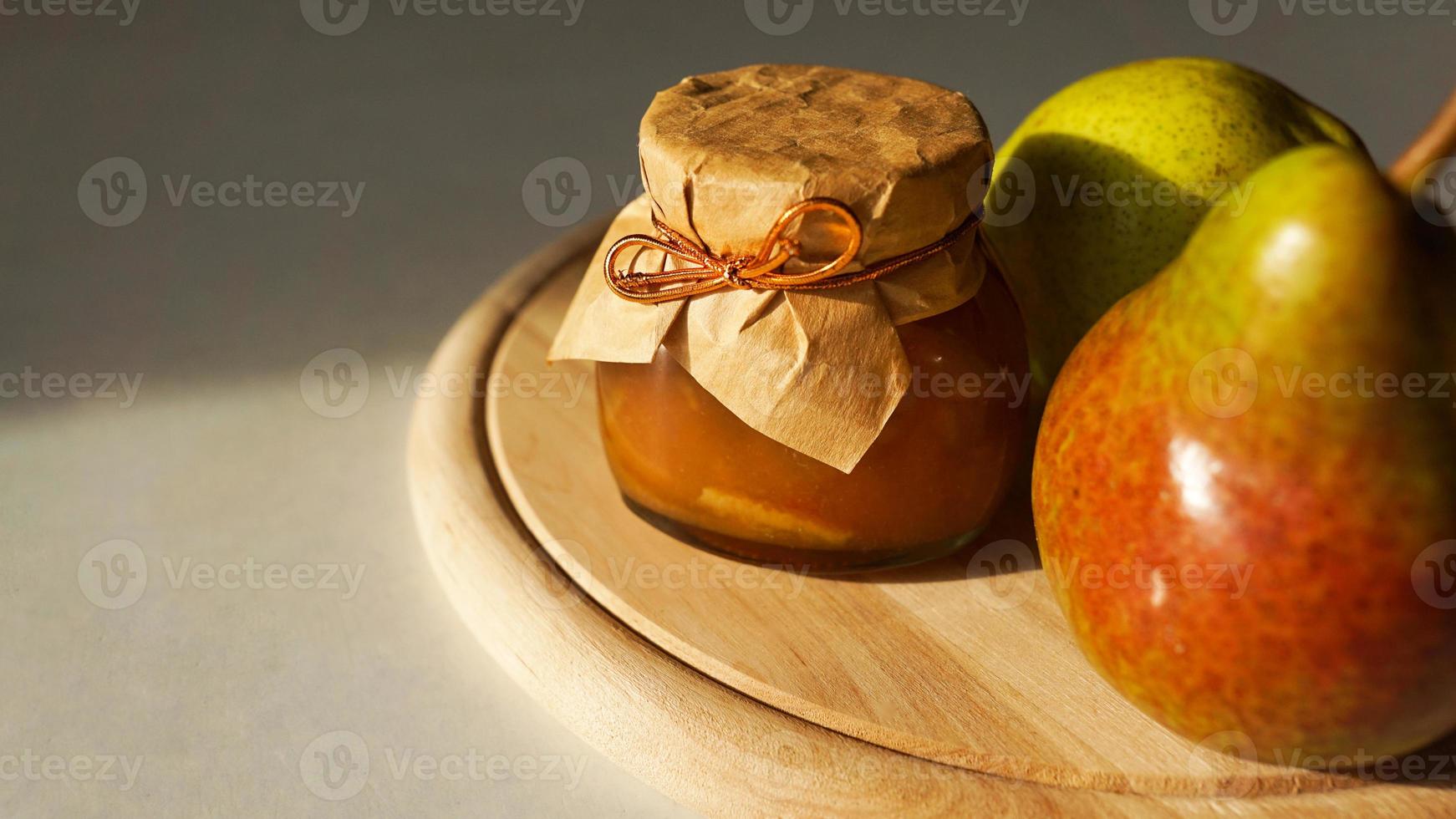 Köstliche Birnenmarmelade und frisches Obst auf Holzschneidebrett. hausgemachte Marmelade foto