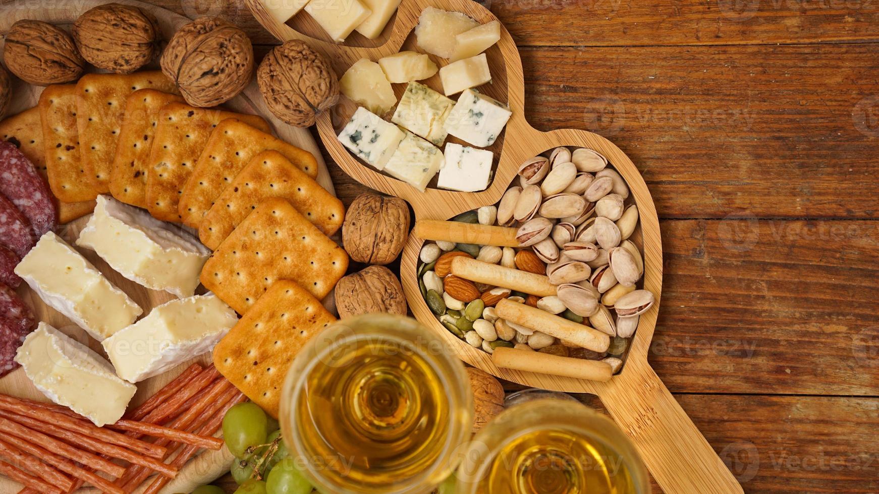 Snacks für Wein. Käse- und Fleischplatte. Wurst, Käse, Nüsse, Trauben, Cracker foto