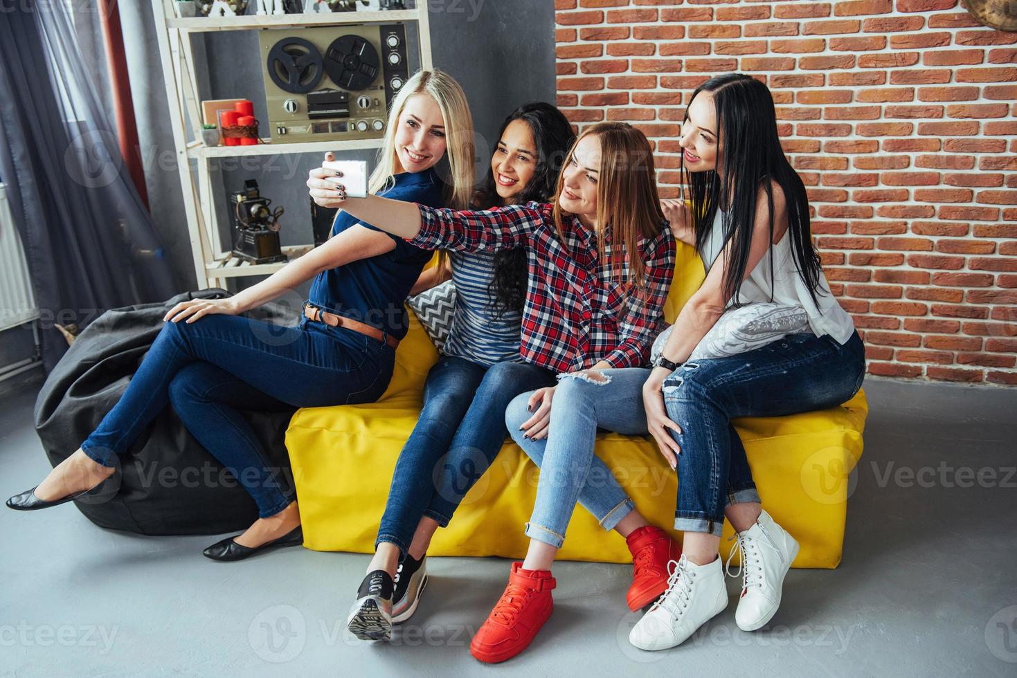 vier schöne junge frau, die selfie in einem café machen, beste freundinnen, die zusammen spaß haben, emotionales lebensstil-menschenkonzept aufwerfen foto