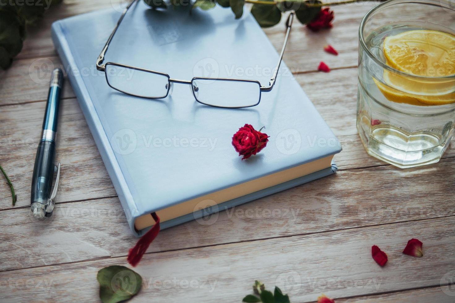 Buchbrille und Blütenblätter foto