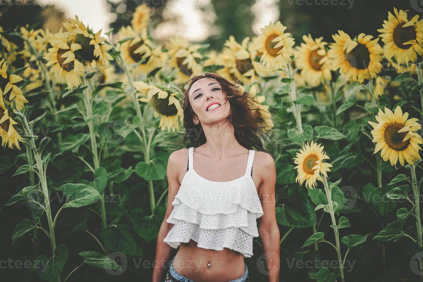 junge Frau im Sonnenblumenfeld foto
