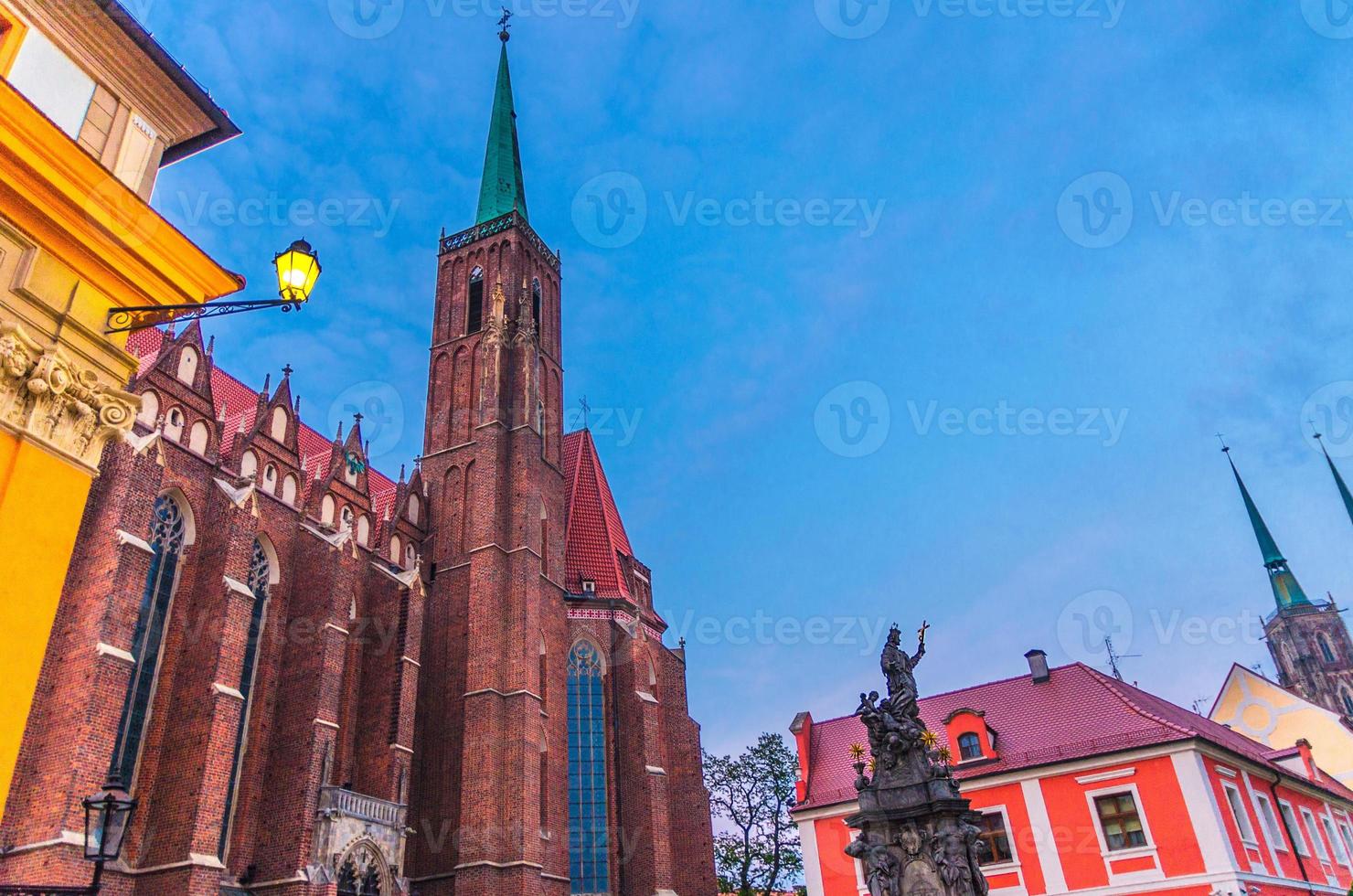 Denkmal und Straßenlaterne auf dem Platz und der katholischen Stiftskirche des Heiligen Kreuzes foto