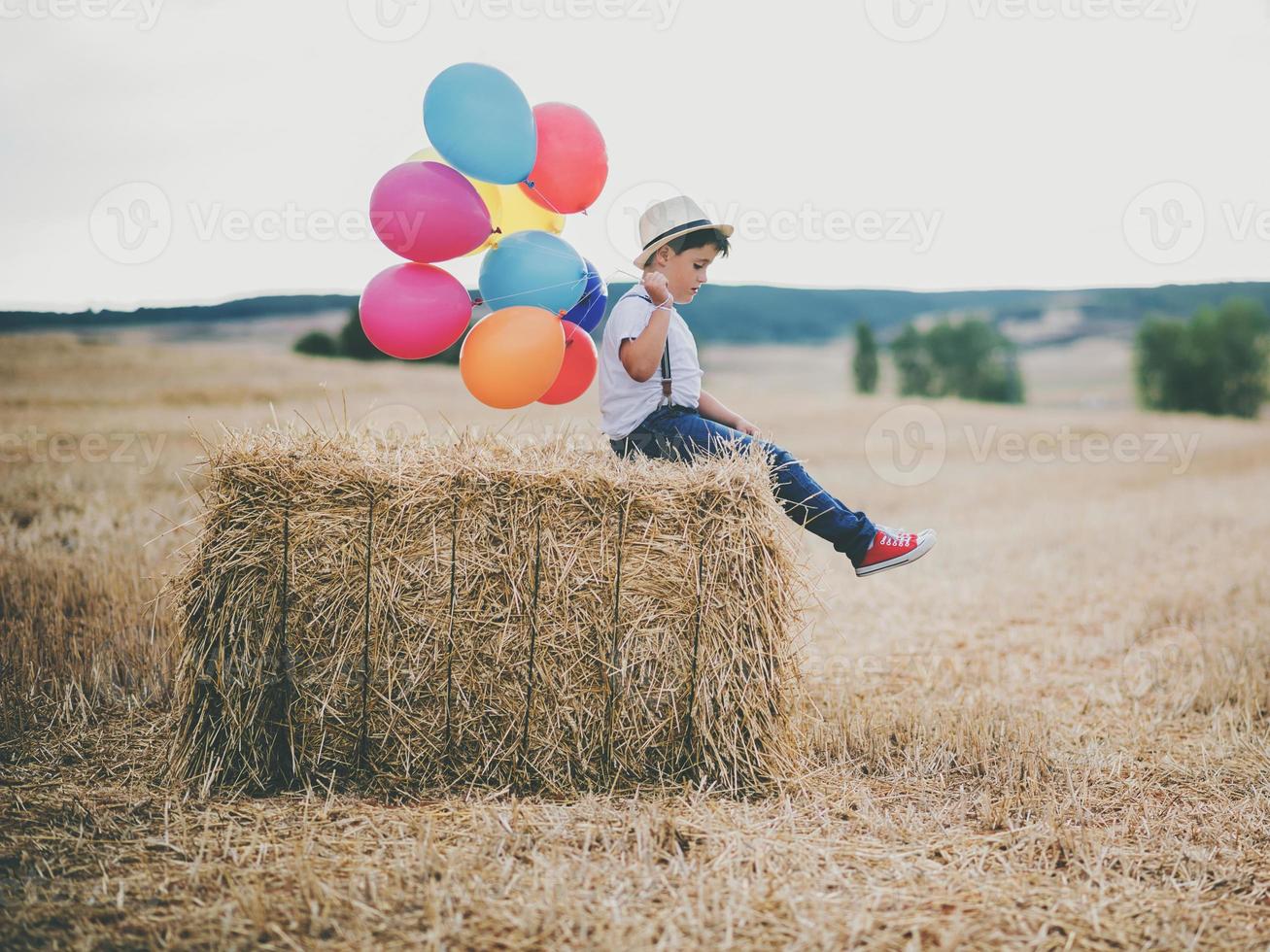 Kind mit Luftballons im Weizenfeld foto