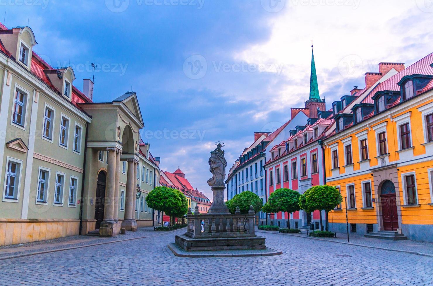 Kopfsteinpflasterstraße mit farbenfrohen Gebäuden und Statue von Madonna und Kinderdenkmal foto