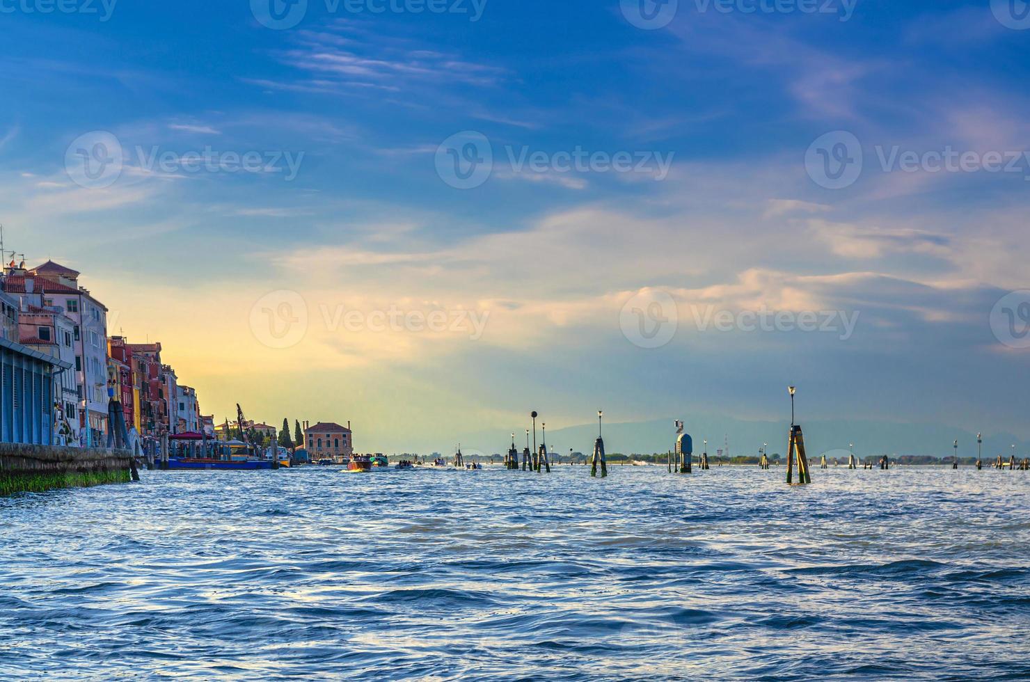 Yachtboote, die auf dem Wasser der venezianischen Lagune zwischen Holzpfählen in der Nähe von Venedig segeln foto