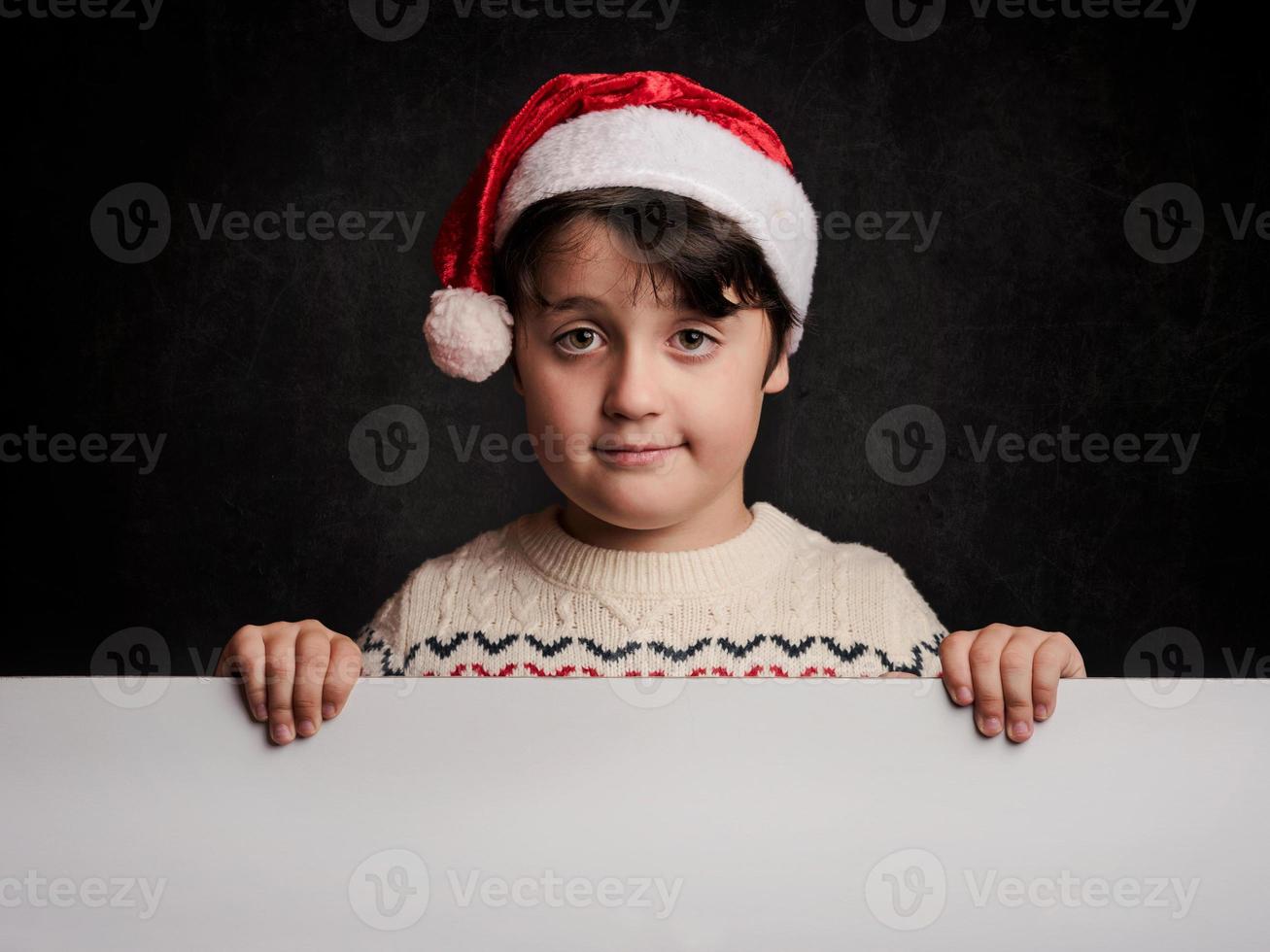 glückliches Kind zu Weihnachten neben einem Plakat foto