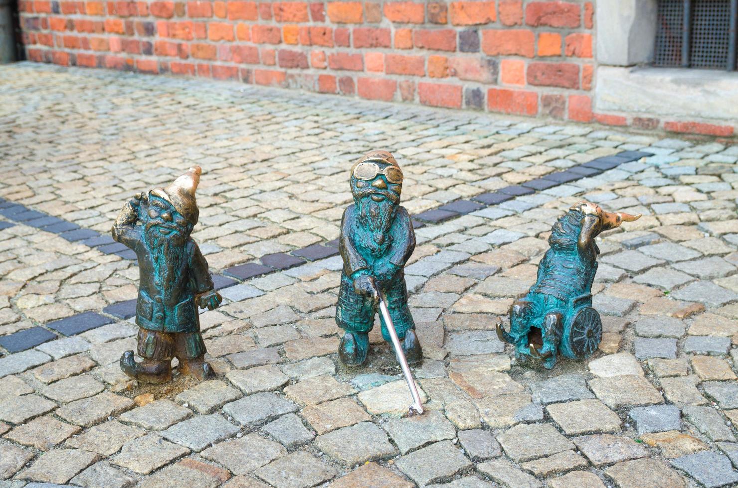 breslau, polen drei zwerge taub, blind mit einem stock und behindert im rollstuhl foto