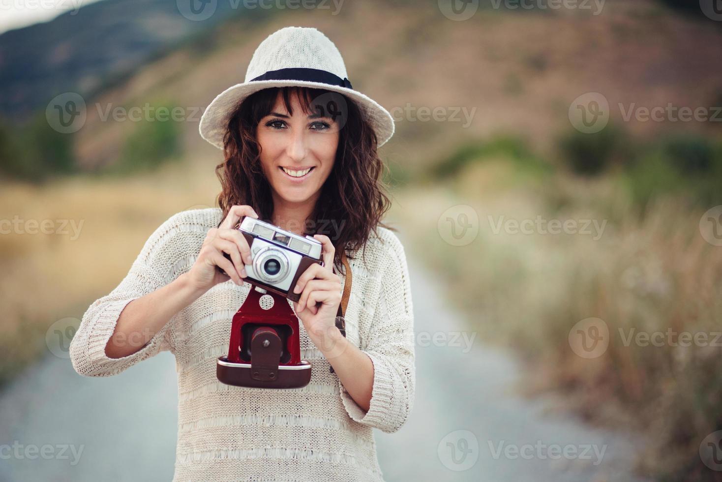 lächelndes Mädchen mit Kamera im Feld foto