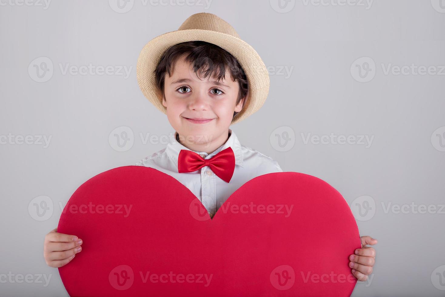 glückliches Kind mit einem roten Herzen foto