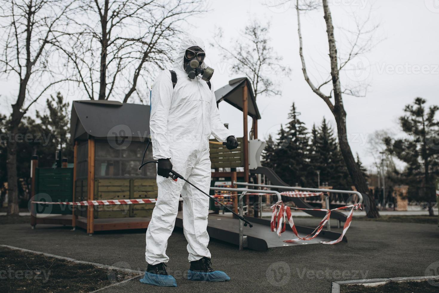 reinigung und desinfektion auf dem spielplatz im stadtkomplex inmitten der coronavirus-epidemieteams zur desinfektionsbemühungen infektionsprävention und bekämpfung von epidemieschutzanzug und maske foto