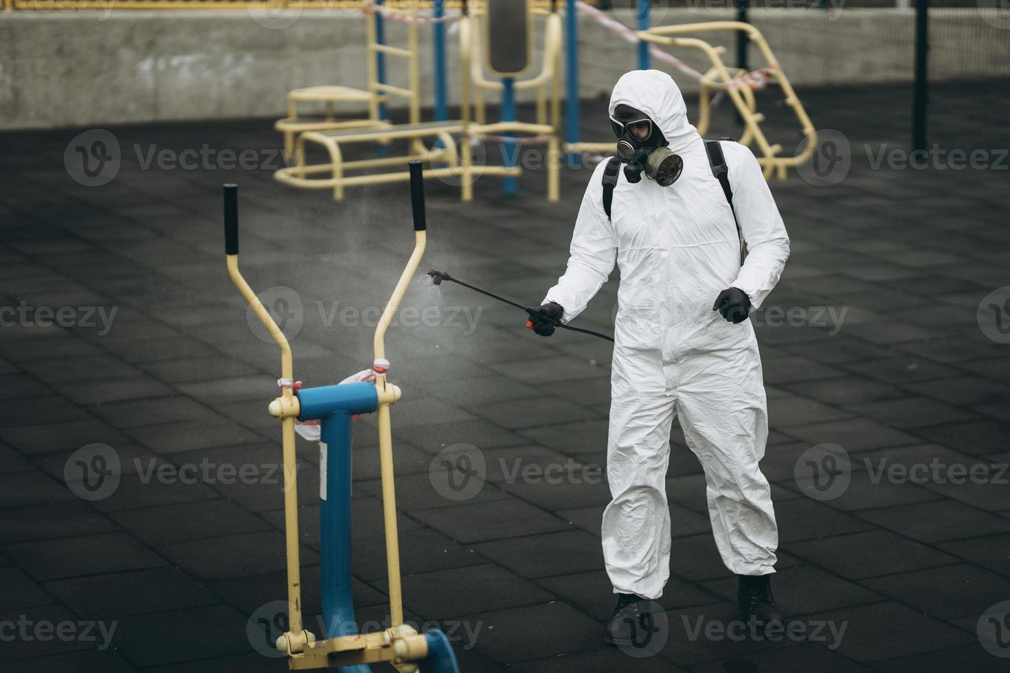 reinigung und desinfektion auf dem spielplatz im stadtkomplex inmitten der coronavirus-epidemieteams zur desinfektionsbemühungen infektionsprävention und bekämpfung von epidemieschutzanzug und maske foto