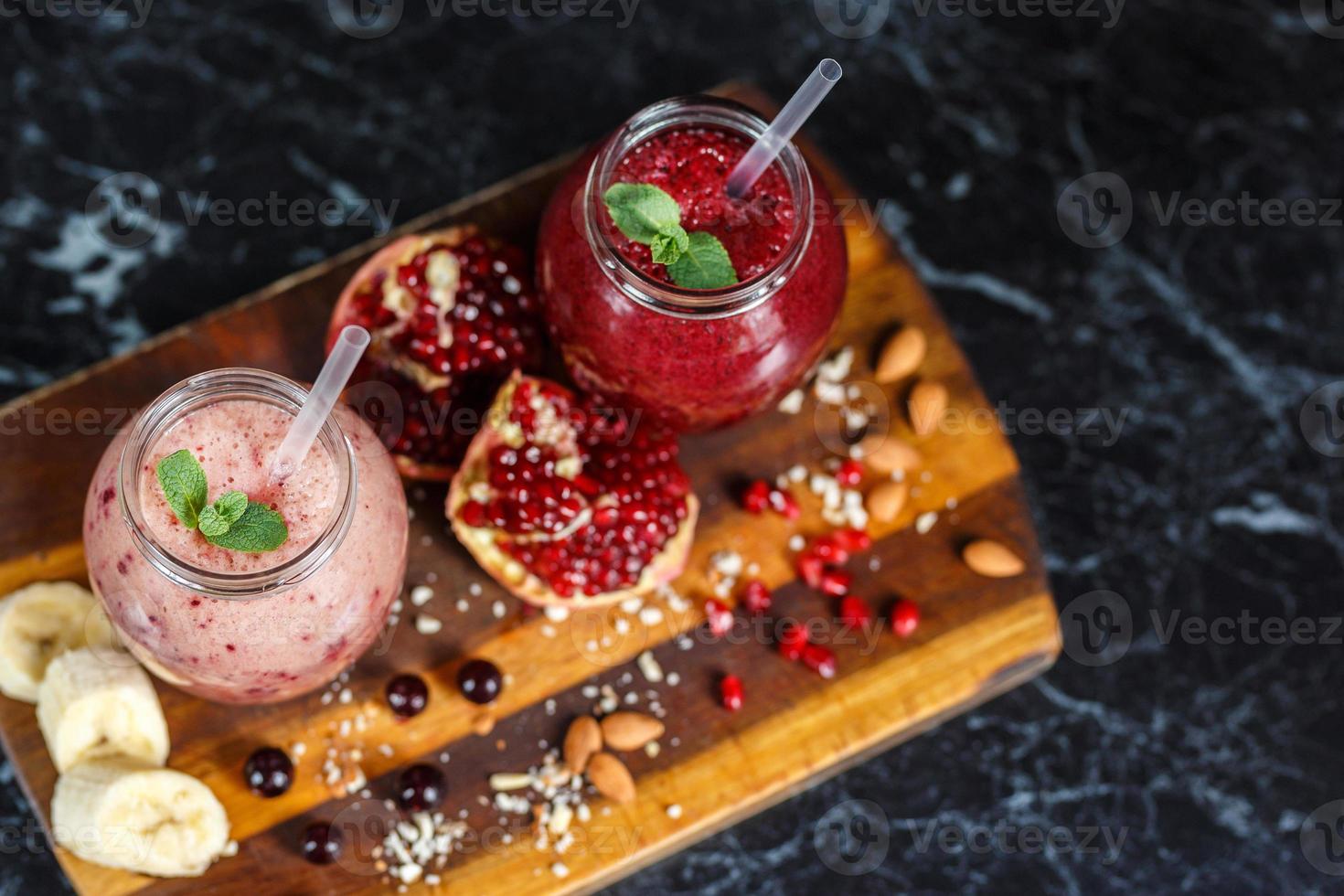 frisch zubereitete Smoothies aus Banane mit Granatapfel und Banane mit Brombeere in der Flasche. Ernährung, gesunder Lebensstil foto