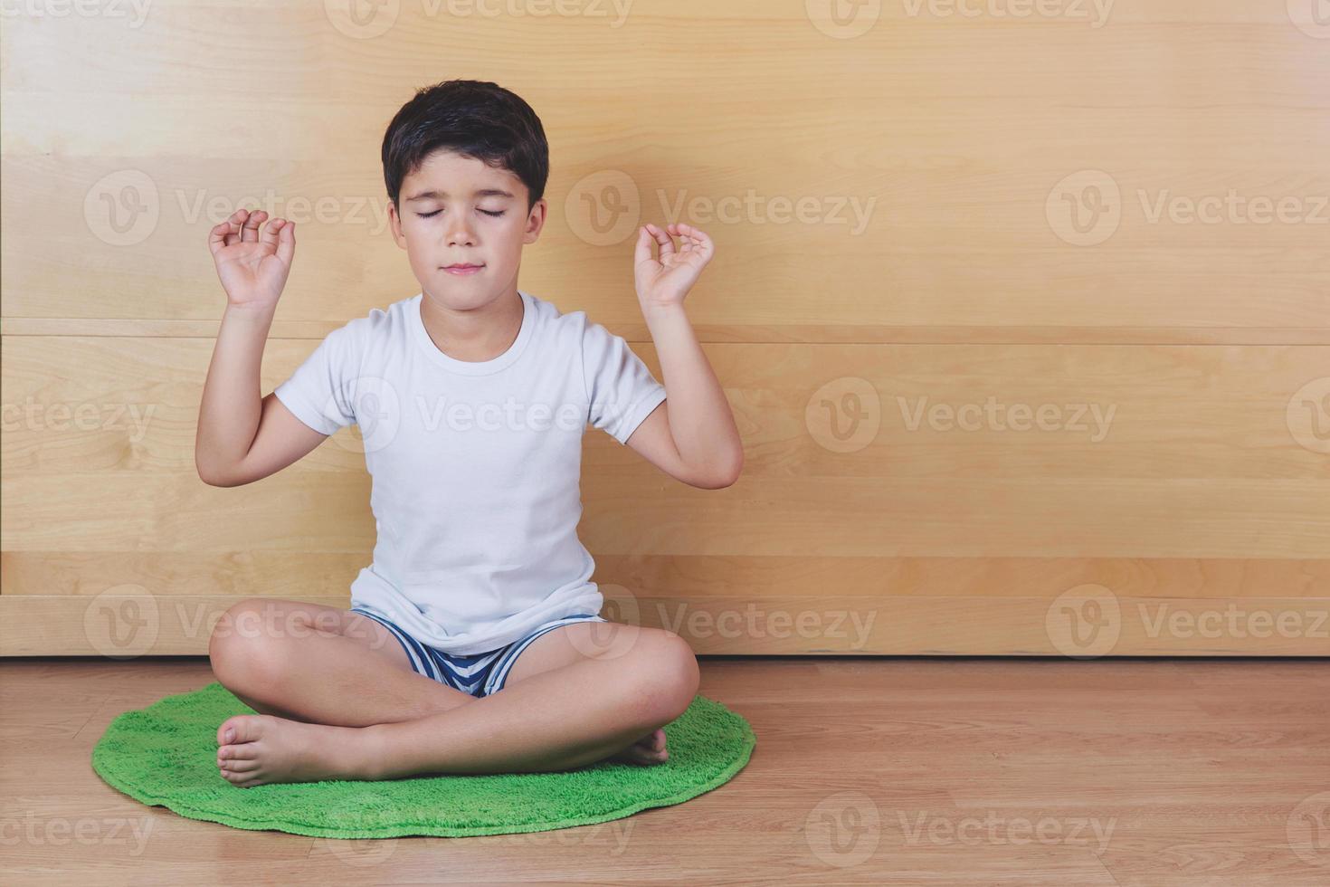 kleiner Junge, der Yoga-Pose praktiziert foto