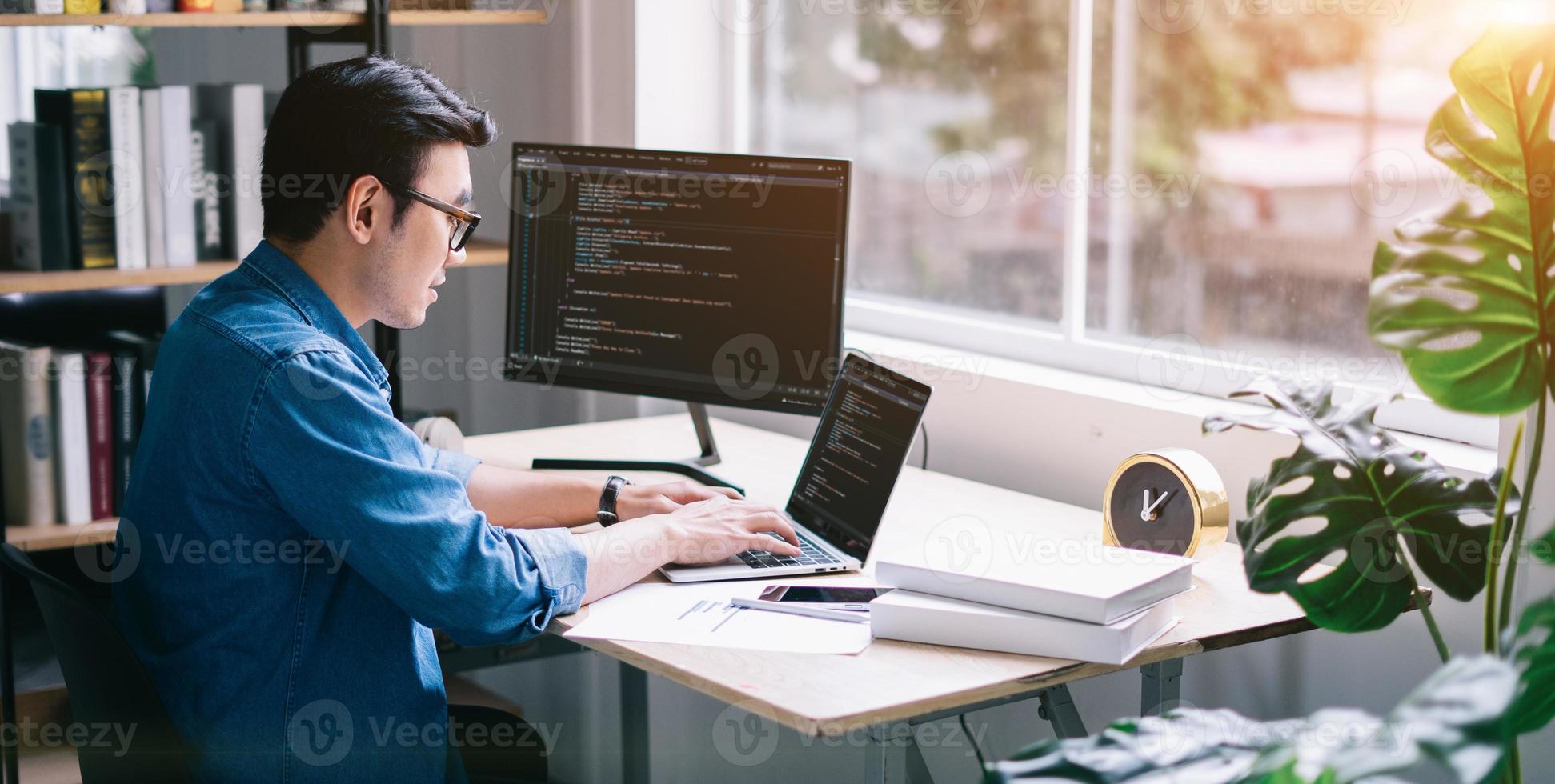 junger asiatischer programmierer, der im büro arbeitet foto