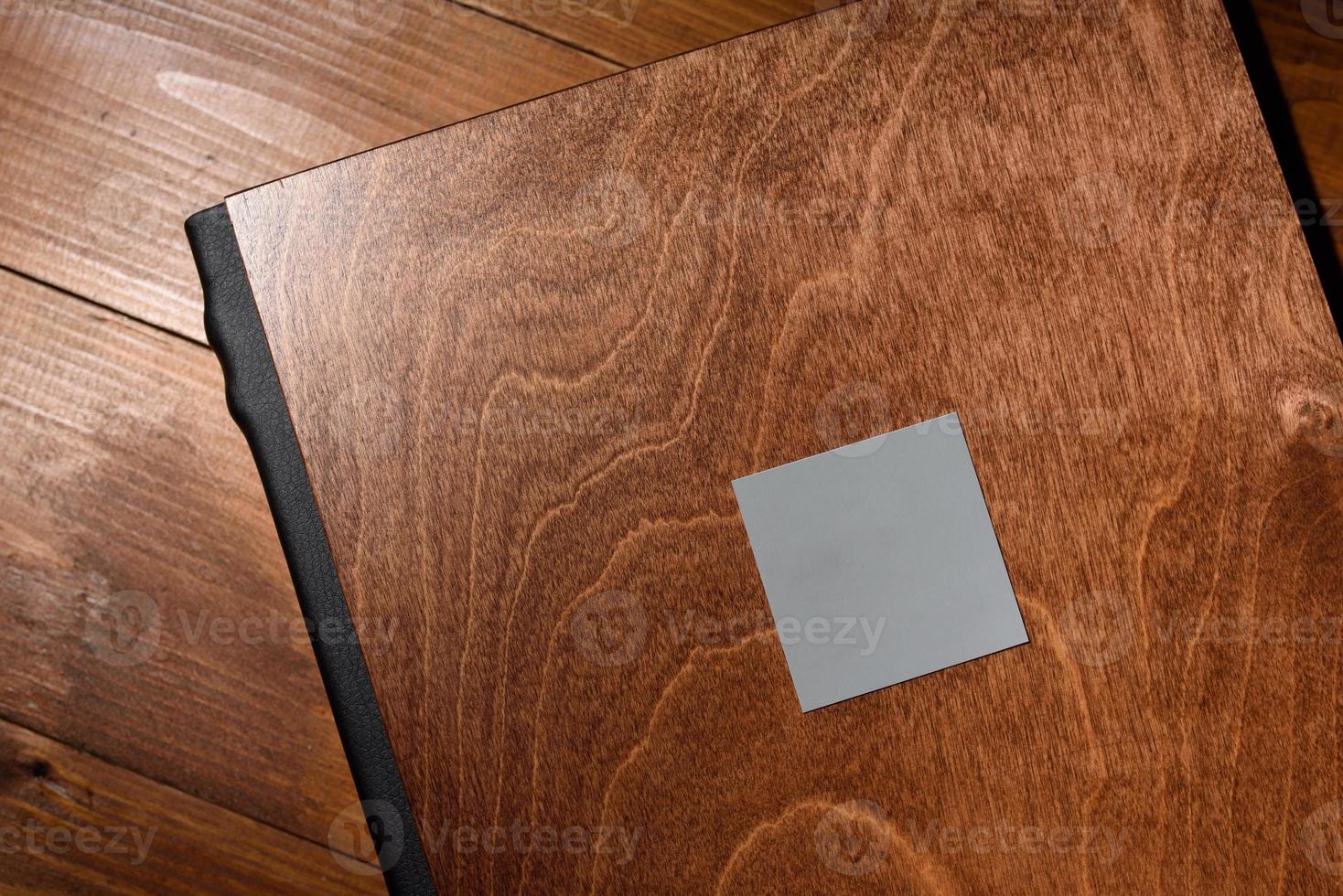 Fotobuch in einem Holzeinband auf einem Holztisch. hartes Licht foto