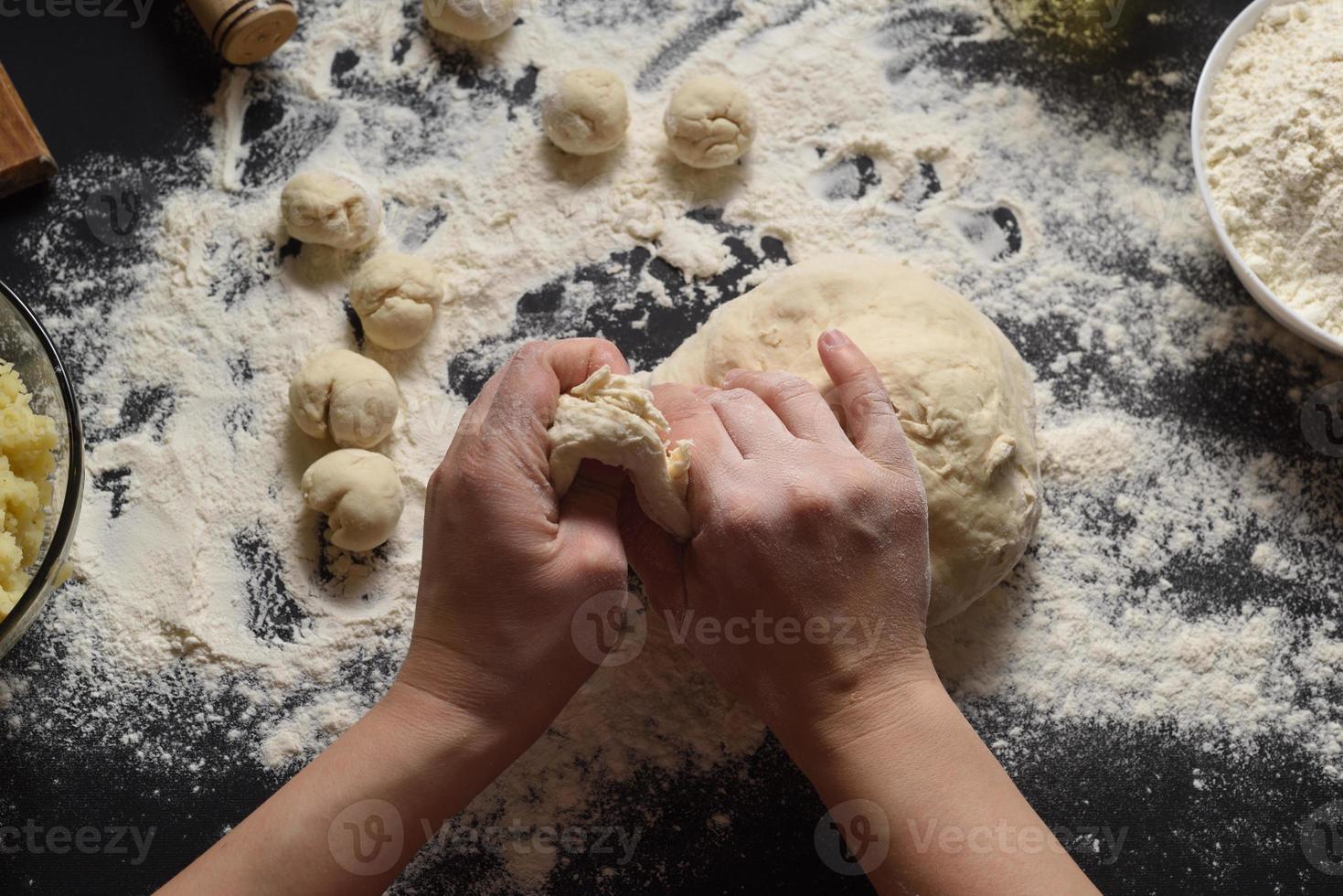 Pizzateig oder Backen auf einem dunkelschwarzen Hintergrund aus Holz. Brot backen, Pizza, Pasta. Draufsicht, horizontales Foto