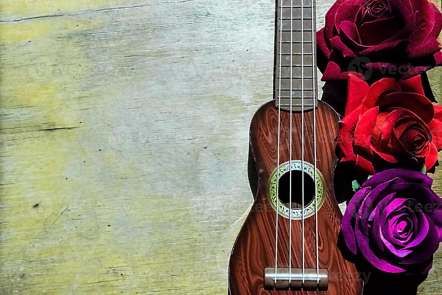 rote Rose auf einem lila Gitarren-Ukulele-Hals und Griffbrett. foto