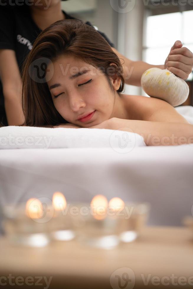 porträt einer jungen schönen asiatischen frau genießt eine massage in einem luxuriösen spa-resort foto