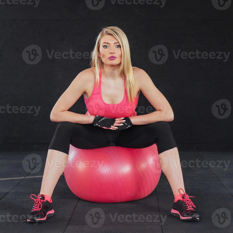 junge attraktive schlanke frau in sportbekleidung, die fitness-übungsball macht. foto