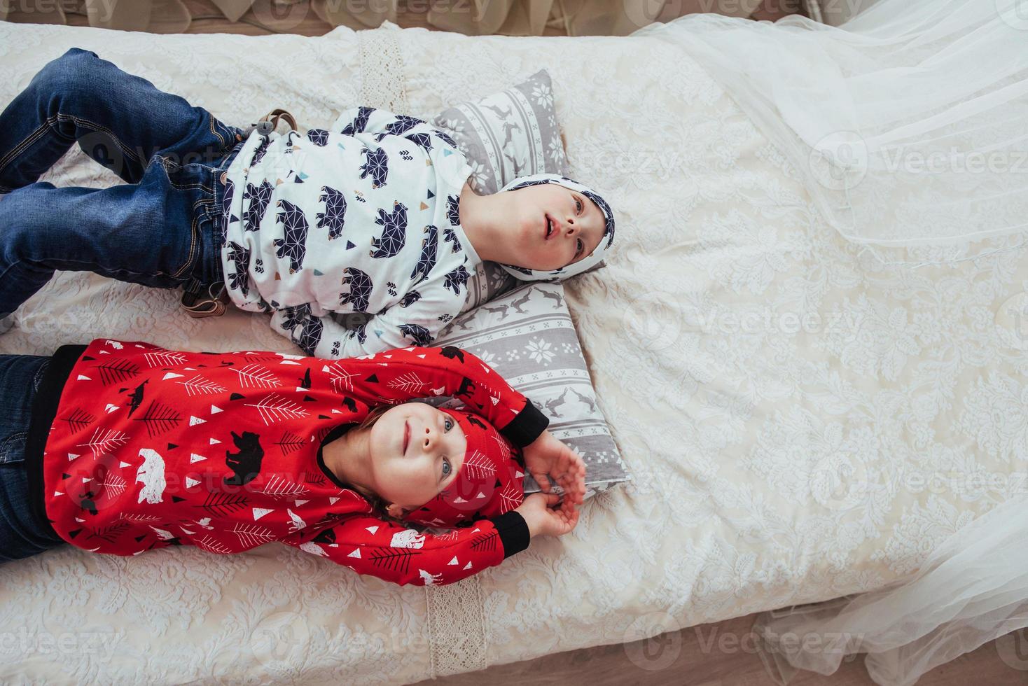 Kind im weichen, warmen Schlafanzug, der im Bett spielt foto