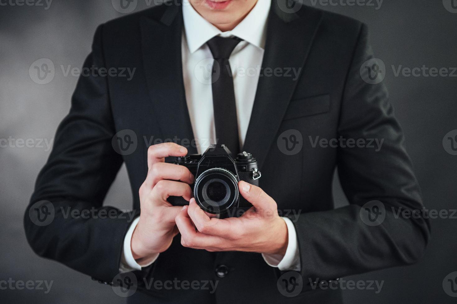 Mann mit schwarzer Digitalkamera. im Studio foto