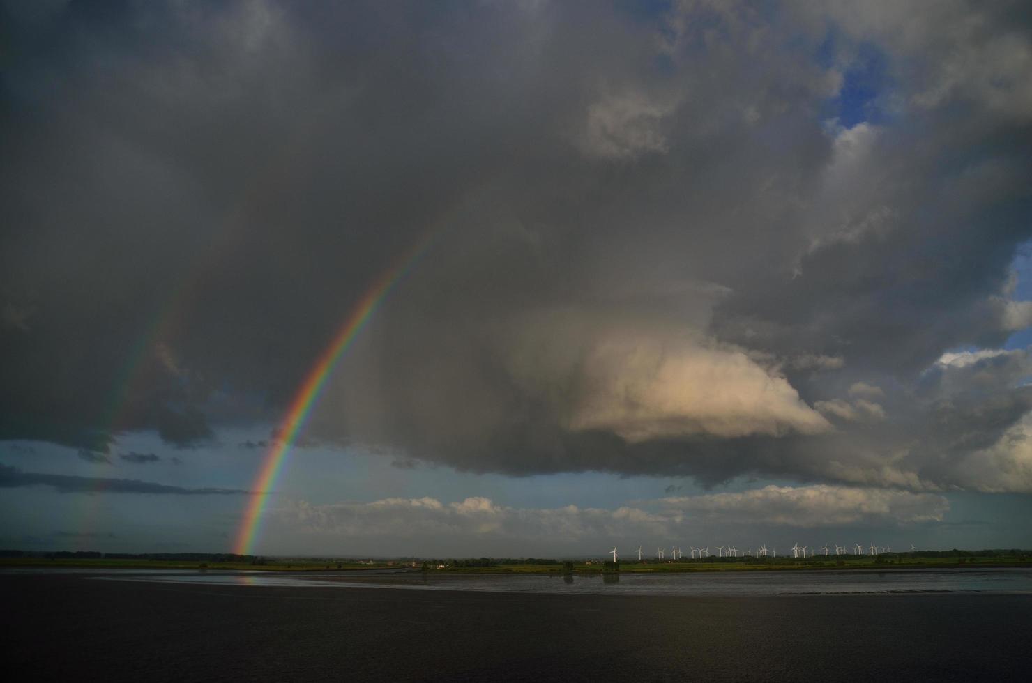 Regenbogen mit Windmühlen auf See foto