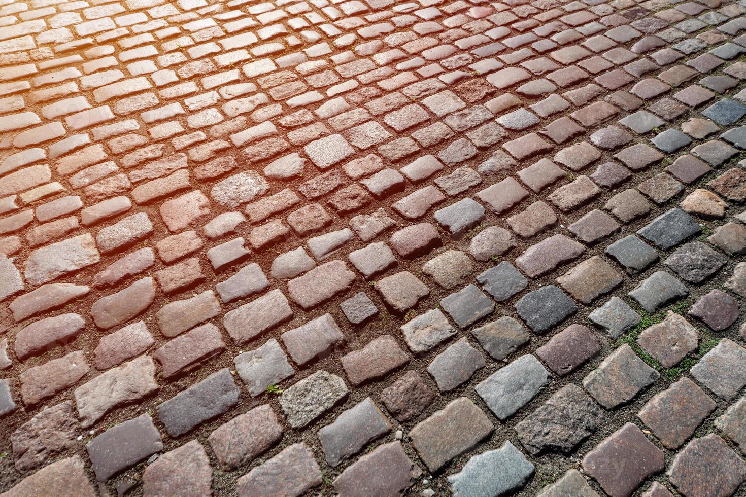 altes pflastersteinmuster, textur des alten deutschen kopfsteinpflasters in der innenstadt der stadt, kleine granitfliesen, antike graue pflaster. foto