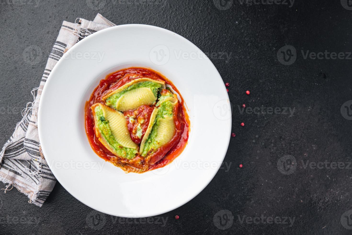 mit Nudeln gefüllte Spinat-Käse-Conchiglie-Füllung garnieren gesunde Mahlzeit foto