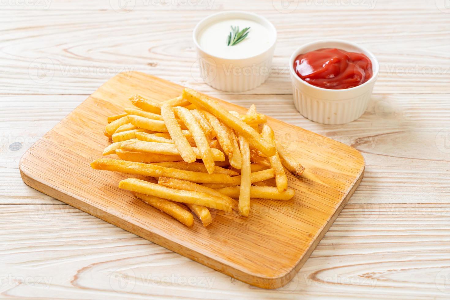 Pommes Frites mit Sauerrahm und Ketchup foto