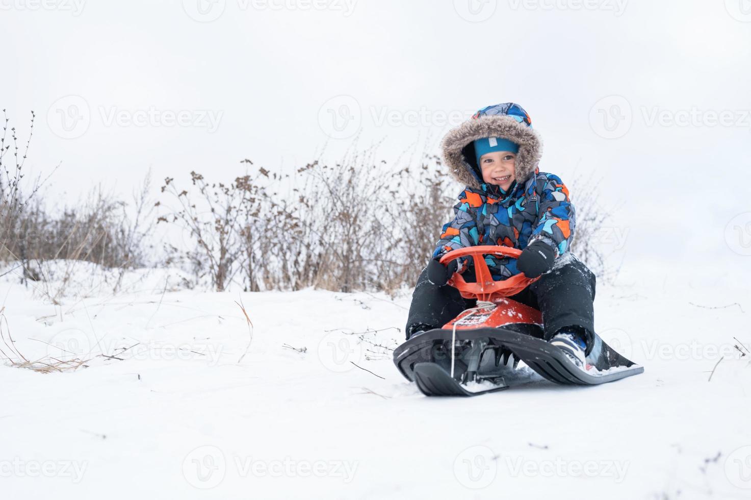 Rutsche, die die Winteraktivität für Kinder hinunterfährt foto