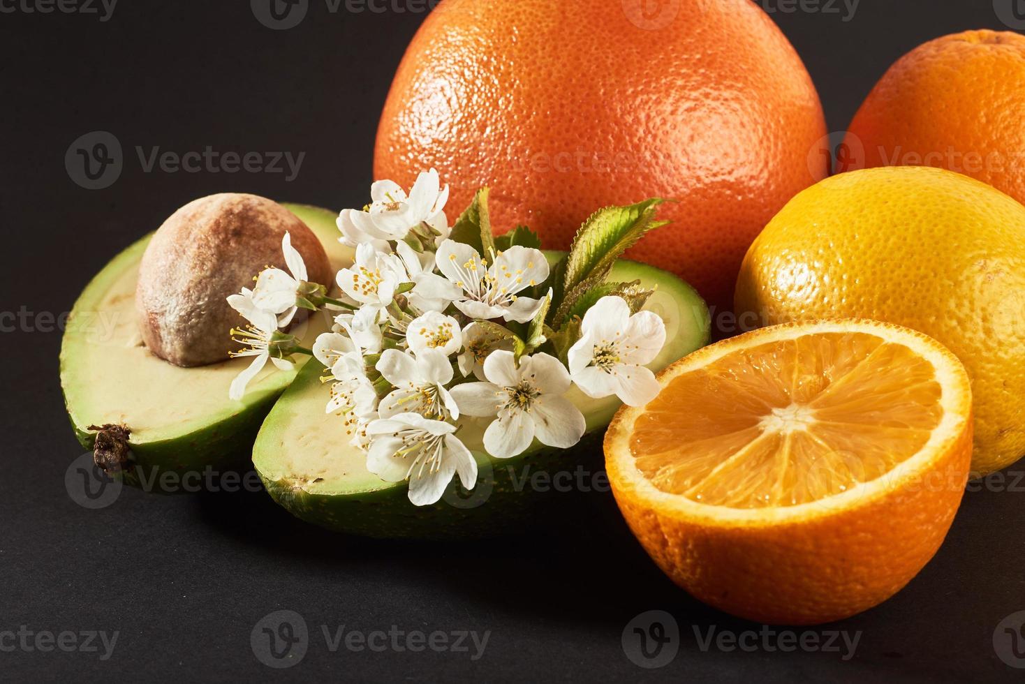 Grapefruit, Orange und Avocado, isoliert auf schwarzem Hintergrund foto