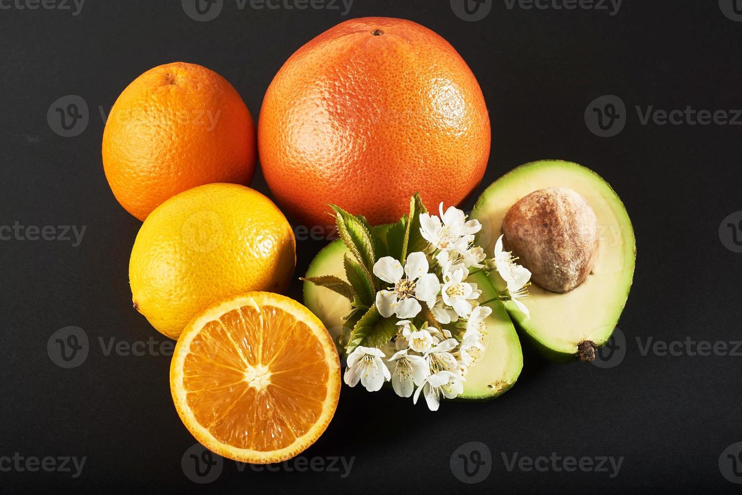 Grapefruit, Orange und Avocado, isoliert auf schwarzem Hintergrund foto