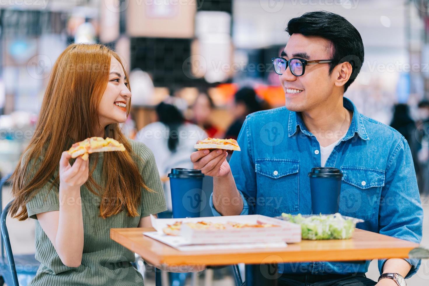 Junge asiatische Paare, die zusammen im Café zu Mittag essen foto