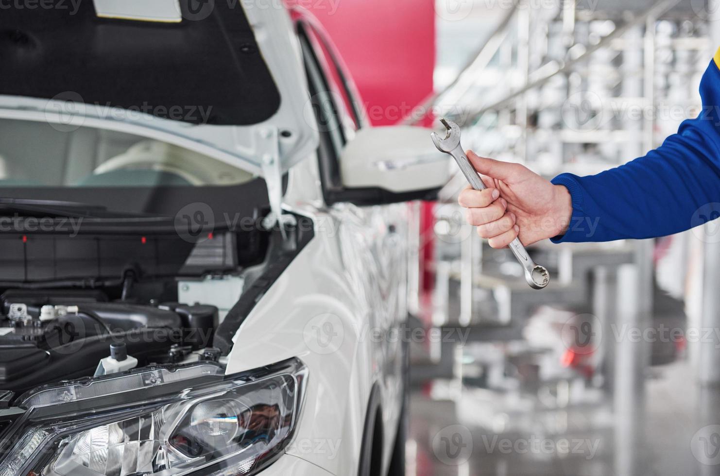 Hände des Automechanikers mit Schraubenschlüssel in der Garage foto