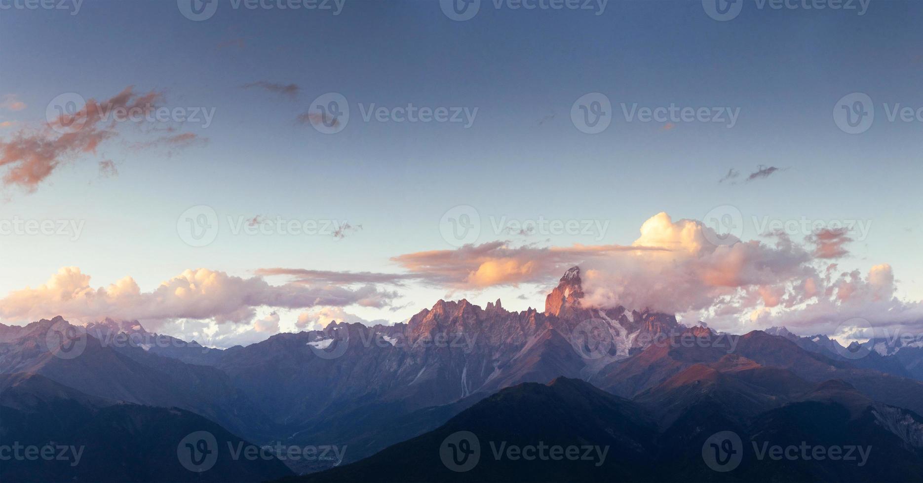 fantastische schneebedeckte Berge in den wunderschönen Kumuluswolken foto