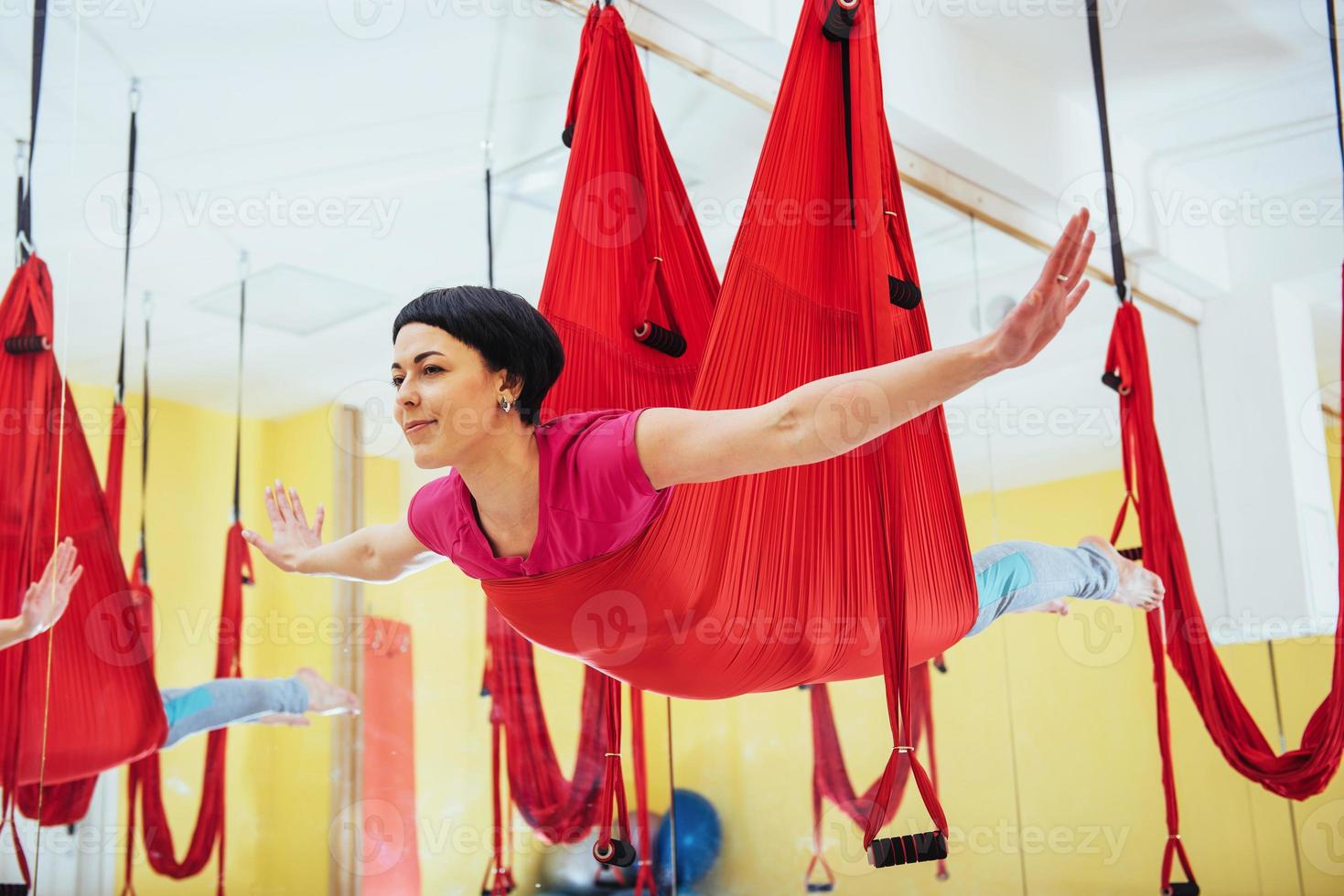 junge Frauen, die im Studio Yoga-Übungen oder Luft-Yoga-Antigravitation machen. foto